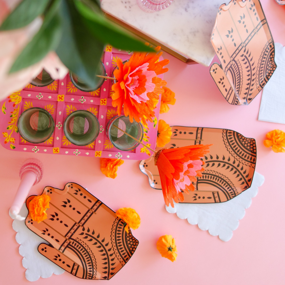 Flatlay of pink and orange party display with Henna Hand plate